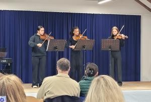 drei Schülerinnen mit Geige auf der Bühne